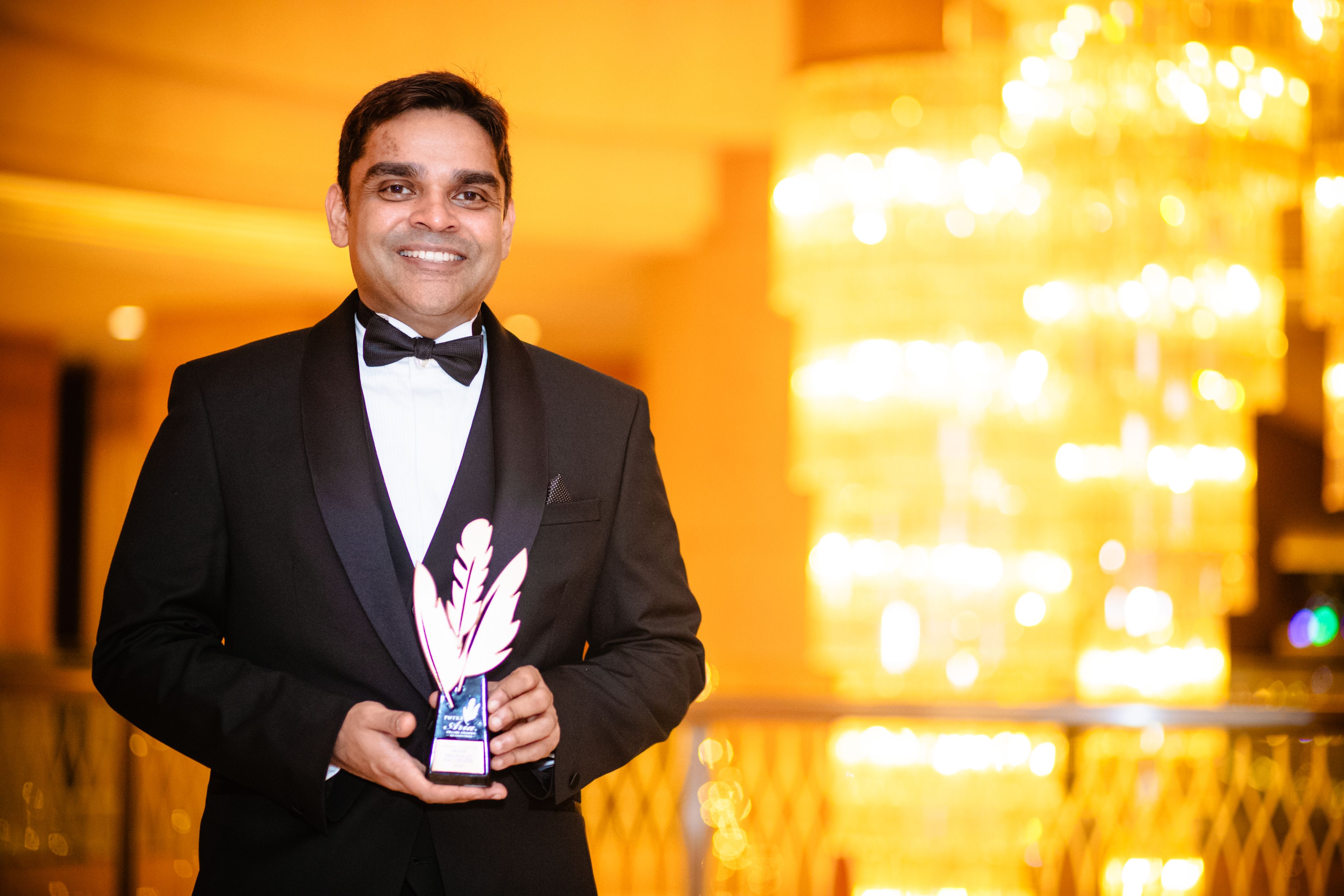 Mr Aria Singham, Managing Director of BAC, beams as he holds the award.