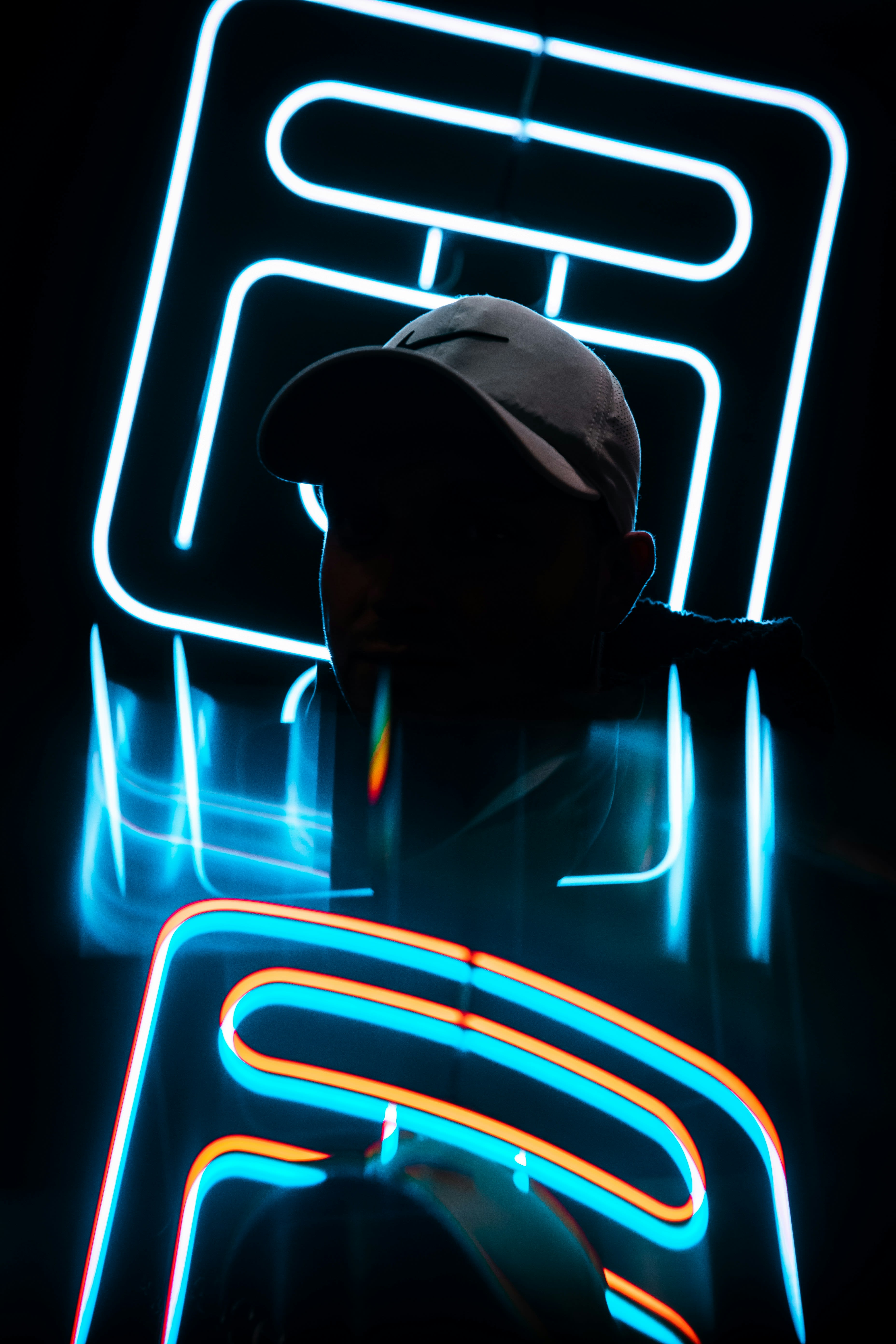 a man standing in front of a neon sign