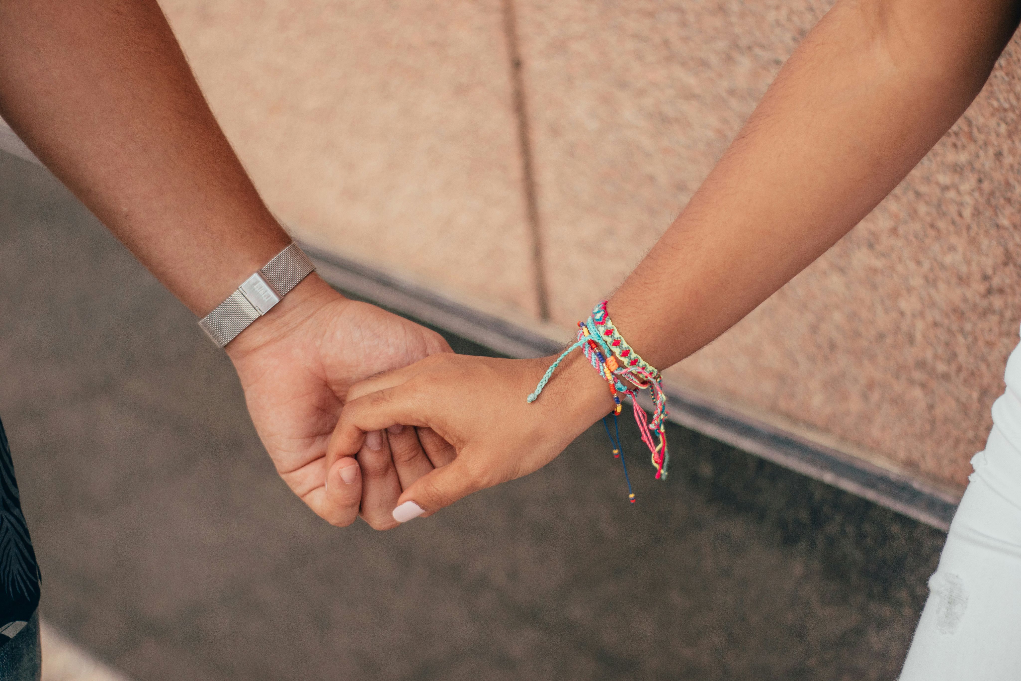 a close up of two people holding hands